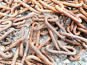 Rusty Metal Chains Piled on a Ground Surface. A heap of intertwined, oxidized metal chains with a close-up view