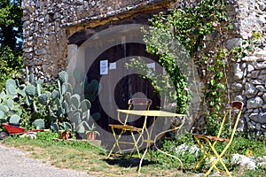 rusty metal chairs and table in front of old farmhouse in southern France