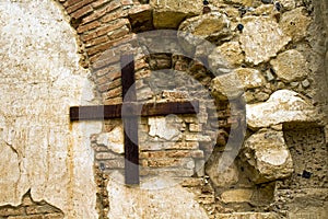 Rusty Metal Cross on a rustic stone wall