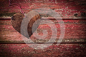 Rusty metal heart on red wooden background
