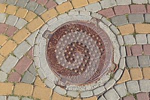 Rusty metal manhole cover in a street