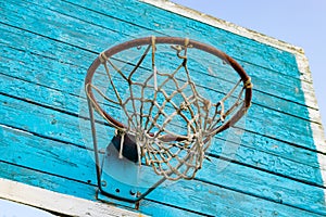 Rusty metal ring with basketball net and wooden shield