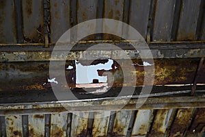 Rusty metal roof with big hole in it