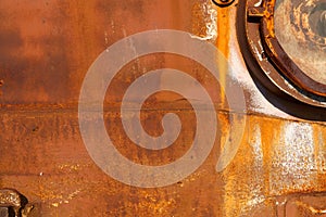 Rusty metal sheet close up. The empty background is a rusty orange color.