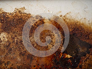 Rusty metal surface with wet rust with smudges of water and drops.