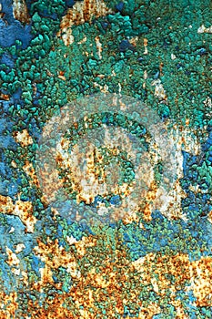 Rusty metal wall, old iron sheet, covered with rust with multi-colored paint. Trace of remnant of old paint in large deep crack on