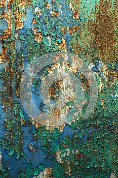 Rusty metal wall, old iron sheet, covered with rust with multi-colored paint. Trace of remnant of old paint in large deep crack on