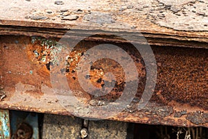 Rusty metal wall, old iron sheet, covered with rust with multi-colored paint. Trace of remnant of old paint in large deep crack on