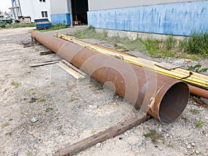 Rusty metal welded pipe near the warehouse