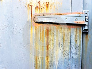 Rusty metallic hinge on door