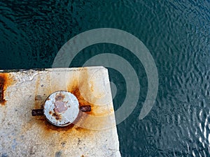 A rusty mooring bolard in two colours