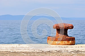 Rusty mooring bollard on port of Podgora