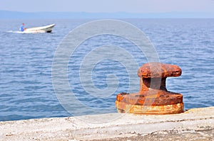 Rusty mooring bollard on port of Podgora