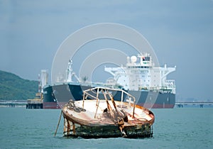 Rusty mooring buoy. Tanker in the background