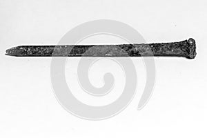 Rusty nail covered with a brown oxidant on a white background