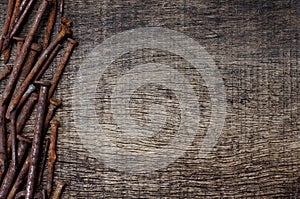 Rusty nails on cracked old wood background