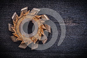 Rusty obsolete cutting tool on wooden board