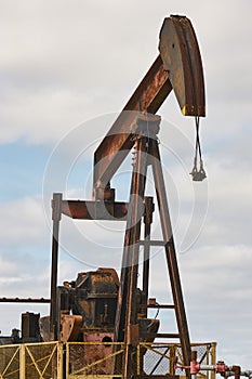 Rusty oil pumping machine. Pump jack. Petroleum extraction. Global warming