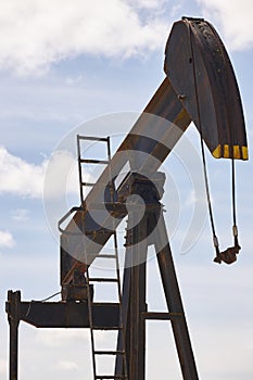 Rusty oil pumping machine. Pump jack. Petroleum extraction. Global warming