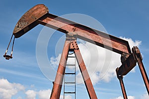 Rusty oil pumping machine. Pump jack. Petroleum extraction. Global warming
