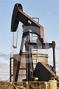 Rusty oil pumping machine. Pump jack. Petroleum extraction. Global warming