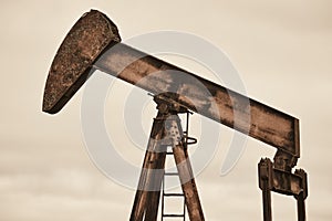 Rusty oil pumping machine. Pump jack. Petroleum extraction. Global warming