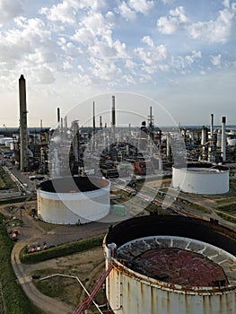 Rusty oil storage tanks at UK oil refinery with chimneys