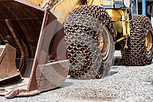 Rusty old anti-skid chain with tractor bucket and excavator bucket