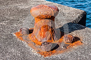 Rusty old bollard on the dock of some harbour in Pico-Azores. photo