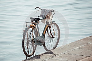 Rusty old bycicle parked on the edge of the holy rive Ganges in Varanasi, India