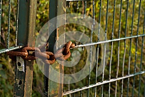 Heavy rusted chain on an iron gate