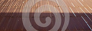 Rusty old corrugated zinc rooftop, viewed from above. Afternoon sun on a rooftop, with half of the roof covered by shade