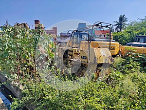 Rusty old digger in a waste area field. Repaired Bulldozer, heavy machinery, focus on arm and bucket