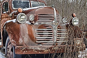 A rusty old dodge truck lies abandoned
