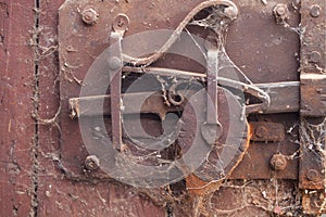 Rusty old door lock mechanism with crackled, scratch, covered with spiders net