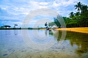 Rusty old fishing boat ship on the quiet yellow sandy beach in the fresh morning sunrise air