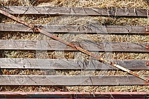 Close up of rusty old flatbed trailer stacked up with hay.
