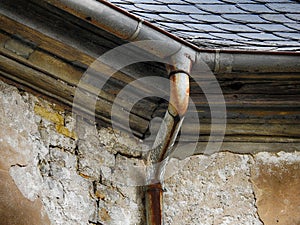 Rusty old gutter in front of an old facade