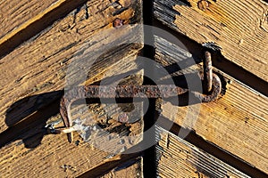 Rusty old hook latch on wooden door exterior