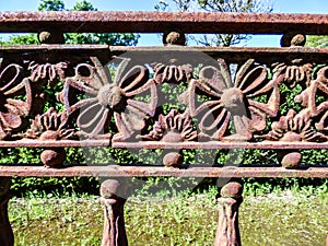Rusty old iron fence with flower details