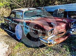 Rusty, old, junked car in the woods