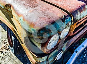 Rusty, old, junked car in the woods