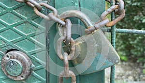 Rusty and old locked metal door. padlock and chain