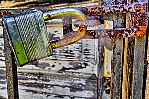 Rusty, old, locked padlock on a latch horizontally