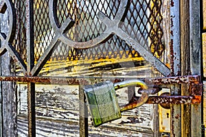 Rusty, old, locked padlock on a latch horizontally