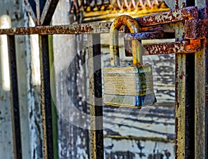 Rusty, old, locked padlock on a latch vertically