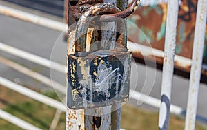 Rusty old padlock. Close up of locked metal gate.