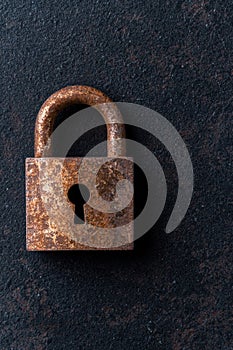 Rusty old padlock on a dark background