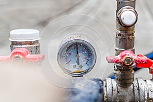 Rusty old pressure gauge in the water supply system close up