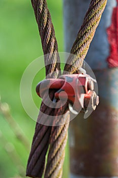 Rusty old steel cable of a former barrier covered with moss